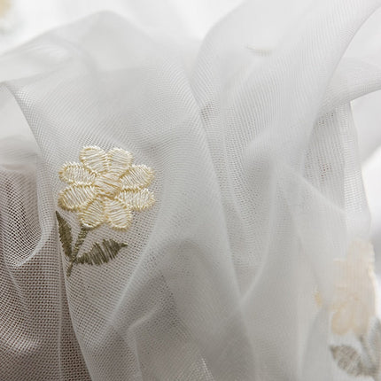 Gardin med små broderede blomster