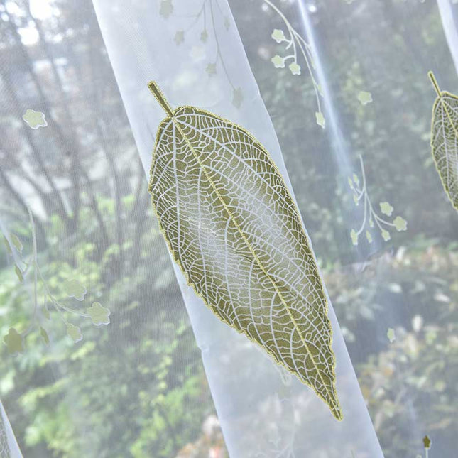 Transparent gardin med grønt bladmønster