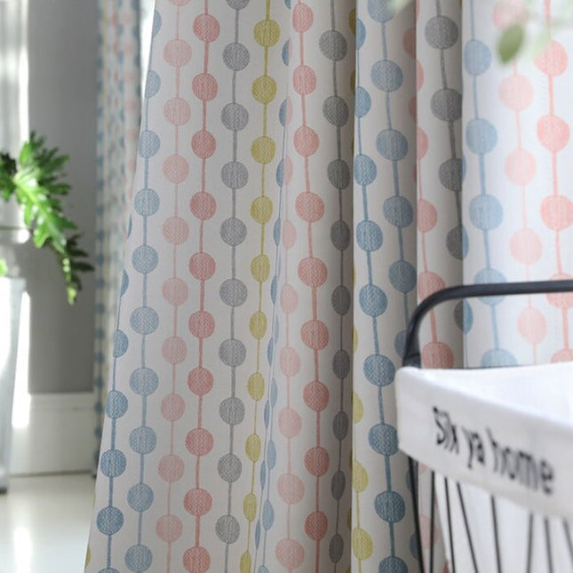 Lyserødt gardin med farverige prikker