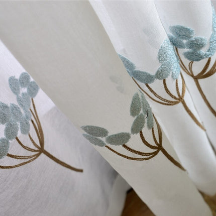 Let gardin med lyseblåt blomsterbroderi