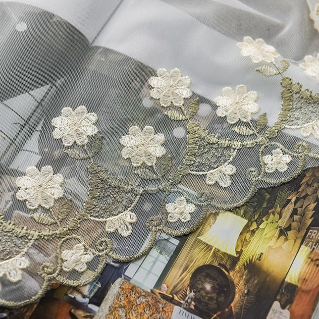 Gardin med små broderede blomster