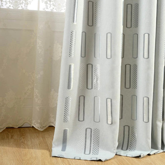 Gråt mørklægningsgardin med grafisk mønster