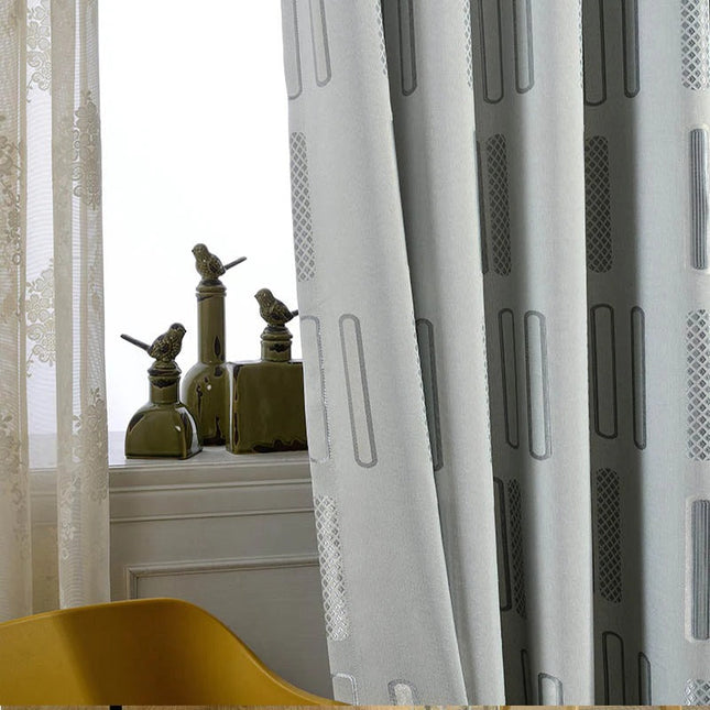 Gråt mørklægningsgardin med grafisk mønster